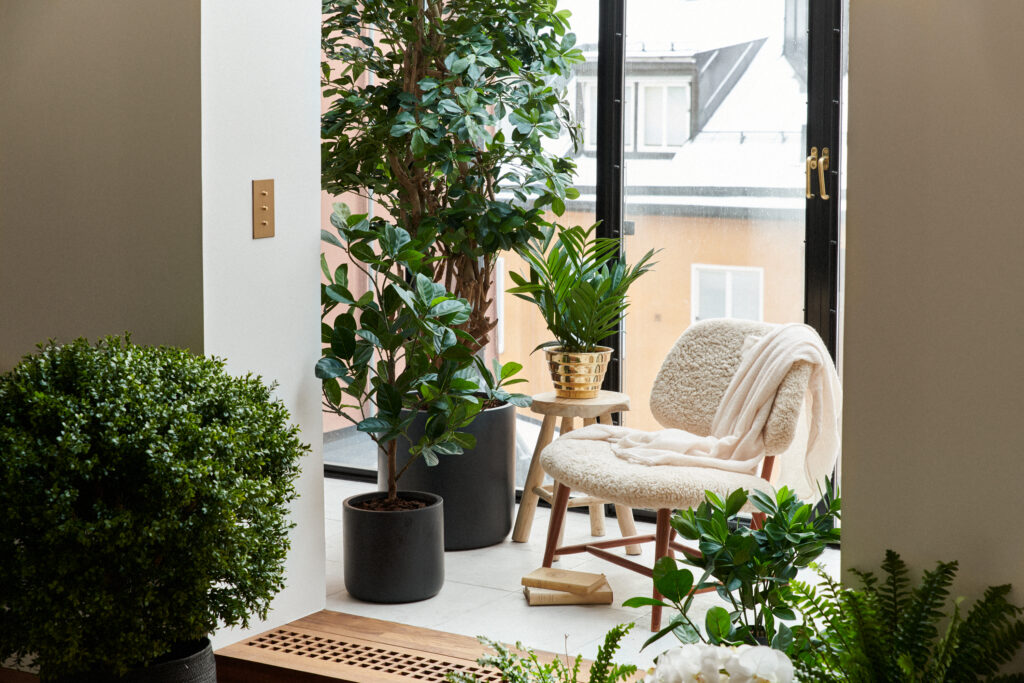 Bilden visar ett modernt rum inrett med konstväxter. Nu kan du enkelt njuta av konstblommor och konstgjorda växter samt konstgjorda träd.